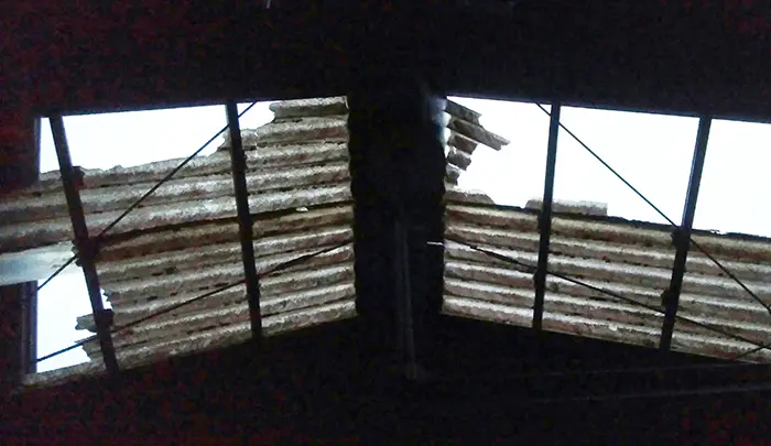 挿絵：とある建物の剥がれた屋根の見上げを撮影した写真画像 (火災保険でのリフォームや修繕ができる例)