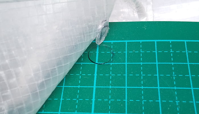 ハトメパンチセットに同梱されている下穴用ポンチでの穴孔け結果を撮影した写真画像2：カッターマットを敷いた例